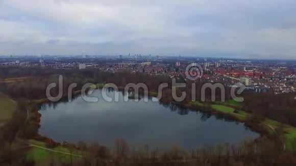 多云天气空中4k无人驾驶飞机飞越宁静的小城市景观和大镜面湖公园视频的预览图