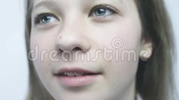 一个年轻女孩的特写肖像一个长着大眼睛的漂亮女孩正站在雨中视频的预览图