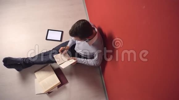 坚持不懈的年轻学生在地板上学习视频的预览图