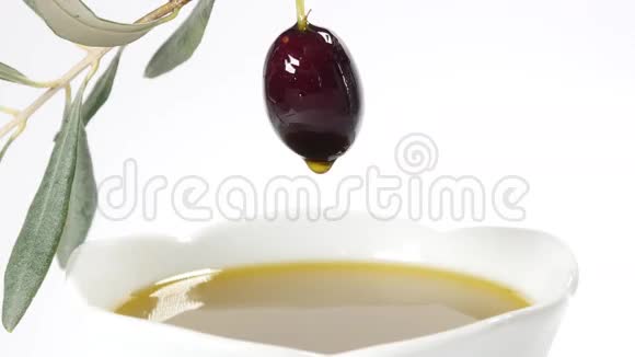 一滴橄榄油从一颗黑橄榄中滑落视频的预览图