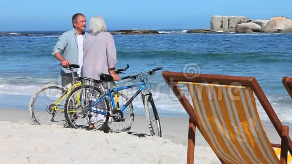骑自行车的人在海滩上讨论视频的预览图