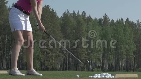年轻女子高尔夫球手在绿色球杆上训练女孩踢球视频的预览图