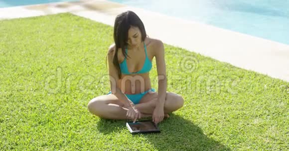 年轻女子在阳光下的平板电脑上冲浪视频的预览图