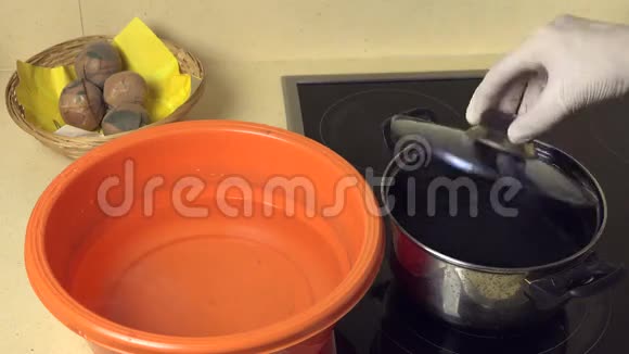 手把漆好的鸡蛋从盆水里拿出来用颜料放到碗里视频的预览图