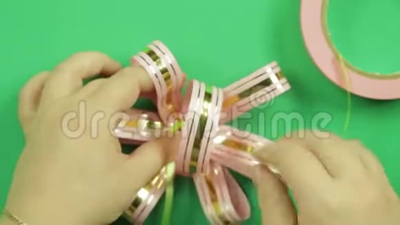 绿色背景上的粉红色彩带礼品蝴蝶结视频的预览图