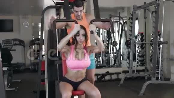 私人教练在健身房帮助妇女锻炼视频的预览图