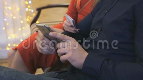 女孩和男人用智能手机观看照片视频的预览图