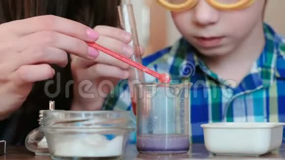 在家做化学实验妈妈和儿子随着试管和烧杯中气体的释放而发生化学反应视频的预览图