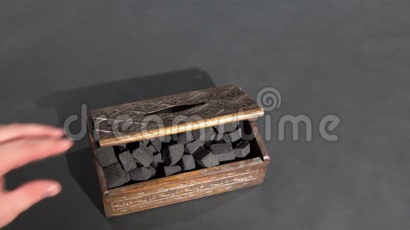 盒子里的黑炭特写手用压煤打开箱子视频的预览图