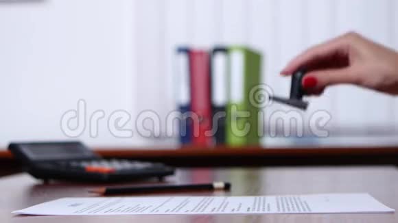 人们在桌子上的文件上贴上邮票关门视频的预览图