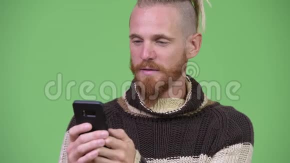 穿着毛衣的帅哥胡子男人用电话视频的预览图