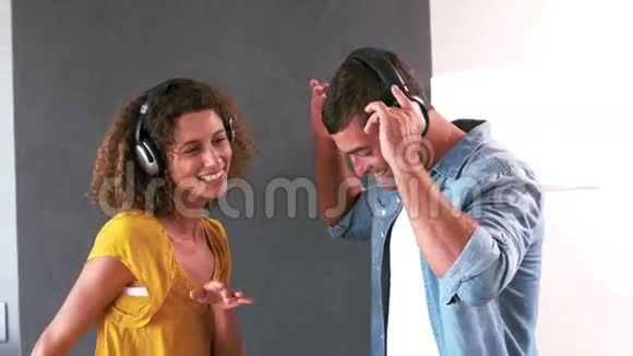 可爱的情侣带着耳机听音乐跳舞视频的预览图
