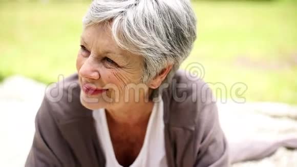 快乐的老妇人在公园里放松思考视频的预览图