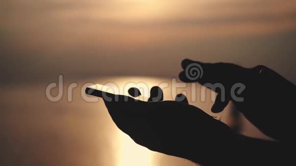 在海滩上的金色夕阳下男性用触摸电话慢动作1920x1080视频的预览图