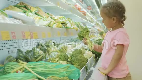 小可爱的小女孩在杂货店里选青菜视频的预览图