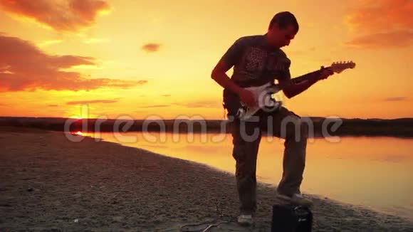 男吉他手弹摇滚日落时跳视频的预览图