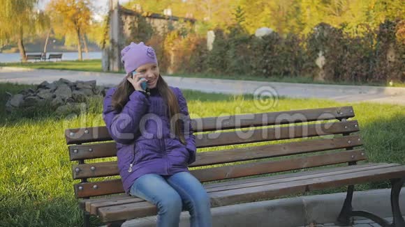 可爱的少女微笑着在电话里交谈牙套慢动作视频的预览图