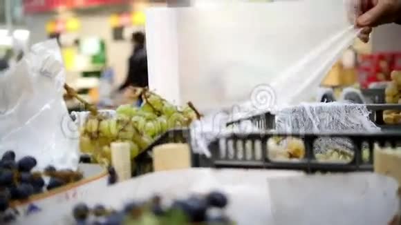 超市顾客在水果部使用塑料包装散焦视频的预览图