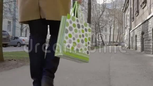 女人腿走路与五颜六色的购物袋视频的预览图