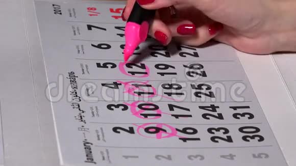 女性手工计划工作日日历上有粉红色标记视频的预览图
