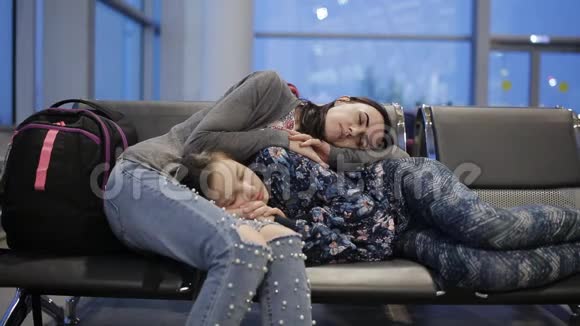 在机场候机室里睡在椅子上的母女视频的预览图