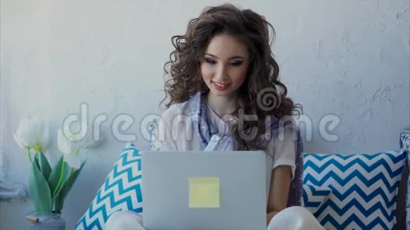 一个年轻的女人用笔记本电脑在网上和朋友聊天视频的预览图