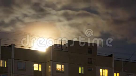 月亮升起在一栋多层建筑的屋顶上视频的预览图