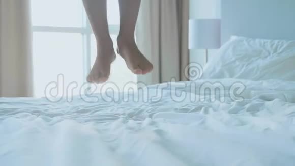早晨小女孩在卧室里慢动作地跳上床视频的预览图