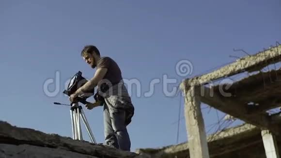 一个人把复古相机放在一栋被毁的大楼附近视频的预览图