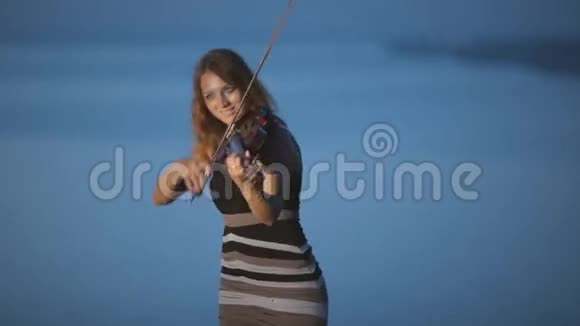 有创意的女孩拉小提琴站在一个视频的预览图