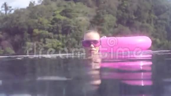 水边和水下的美丽年轻女子穿比基尼和紫色太阳镜游泳在无限屋顶游泳池视频的预览图