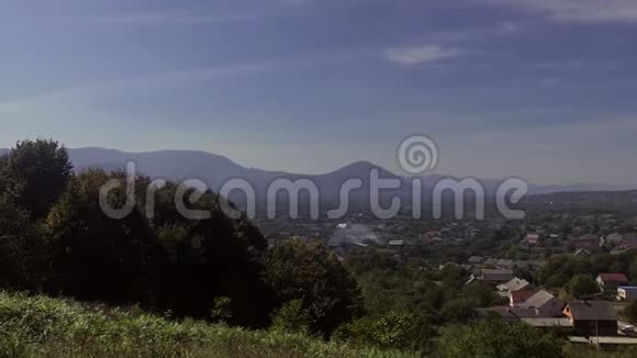 山谷的景观在远处你可以看到群山在低地有一个村庄视频的预览图
