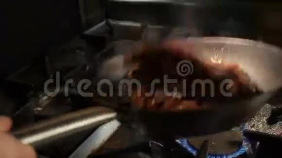 露天火焰上方的锅上的人为切菜视频的预览图