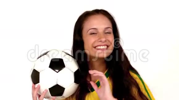 可爱的黑发女人拿着足球指着视频的预览图