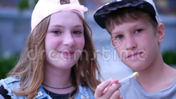开心哥哥姐姐在公园户外吃冰淇淋快乐的兄弟姐妹快乐少年家庭视频的预览图