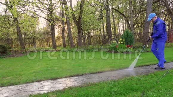 园丁用高压喷水冲洗人行道视频的预览图
