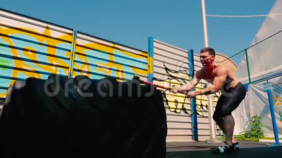 运动员用重锤敲打橡胶轮胎视频的预览图