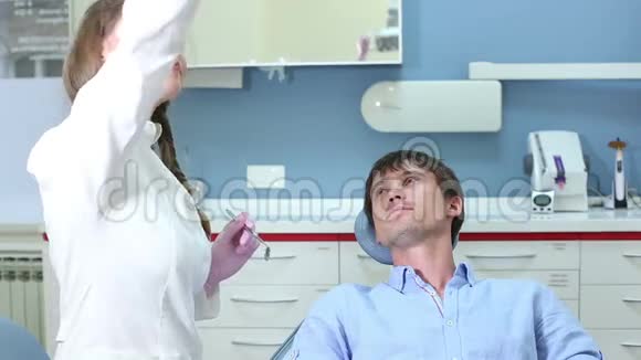 女性牙医做常规检查年轻男性病人视频的预览图