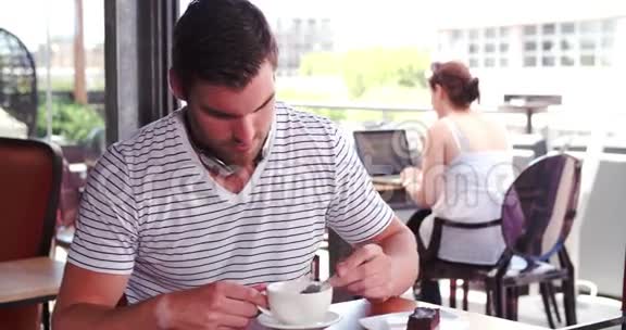 数字平板听音乐的人坐在咖啡厅视频的预览图