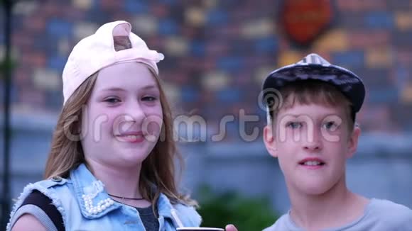 开心哥哥姐姐在公园户外吃冰淇淋快乐的兄弟姐妹快乐少年家庭视频的预览图