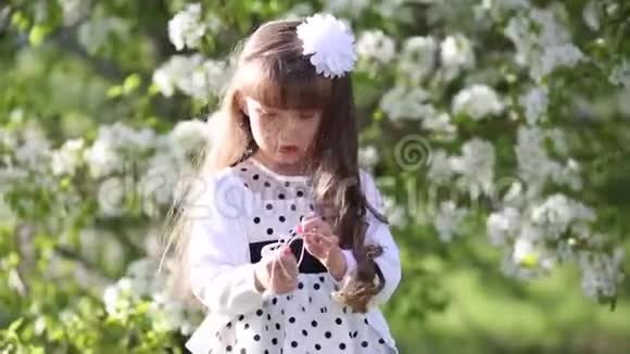 一个穿着白色衣服的女孩通过小音频耳机听音乐视频的预览图