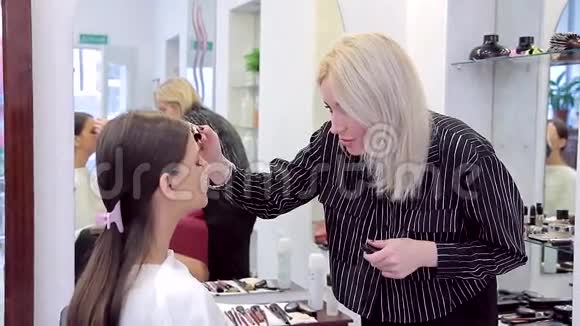 化妆师在画室里用睫毛膏做模特视频的预览图