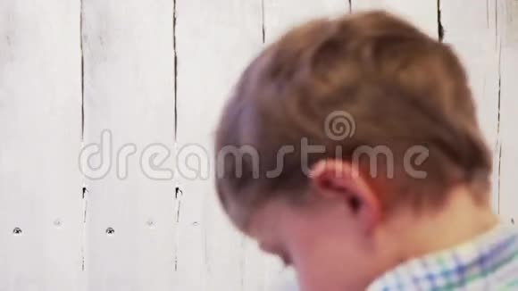 小男孩用白色的独立栏杆画木面视频的预览图