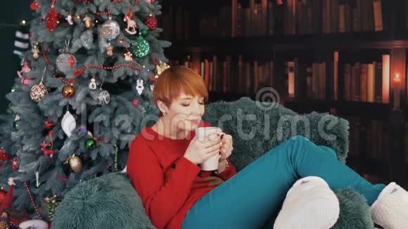 美丽的红发女人在扶手椅上视频的预览图