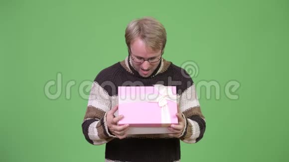 工作室拍摄的快乐帅哥打开礼物盒看上去很惊讶视频的预览图