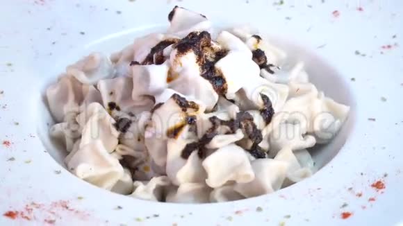 酸奶和辣酱在著名的传统土耳其食品曼蒂上旋转射击视频的预览图