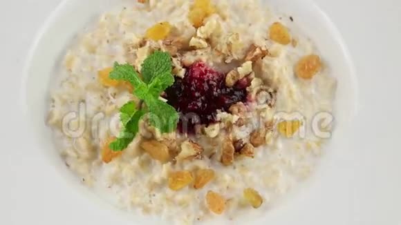 健康早餐燕麦粥葡萄干核桃和牛奶循环视频的预览图
