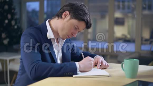 坐在办公桌前写笔记的人视频的预览图