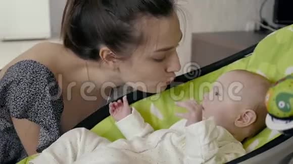 爱的母亲和她的婴儿在儿童电动座椅视频的预览图