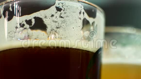 一杯又黑又淡的啤酒特写啤酒杯中的IPA和Lagger朋友们在酒吧喝啤酒视频的预览图